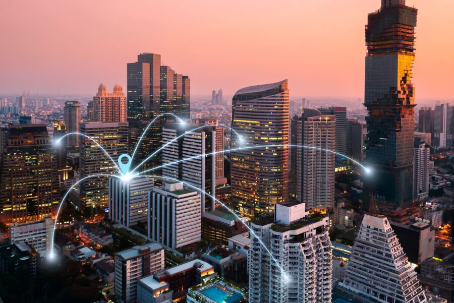 Downtown office towers at dusk, linked by glowing network lines across the city skyline